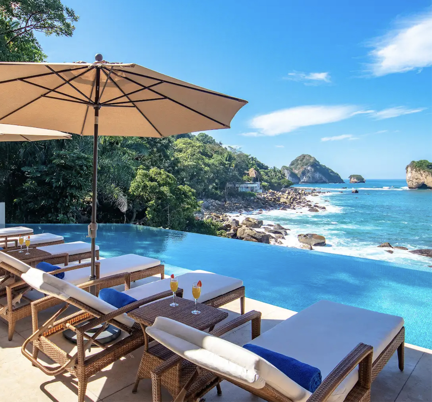 Infinity pool terrace with loungers overlooking the Pacific coastline in Puerto Vallarta